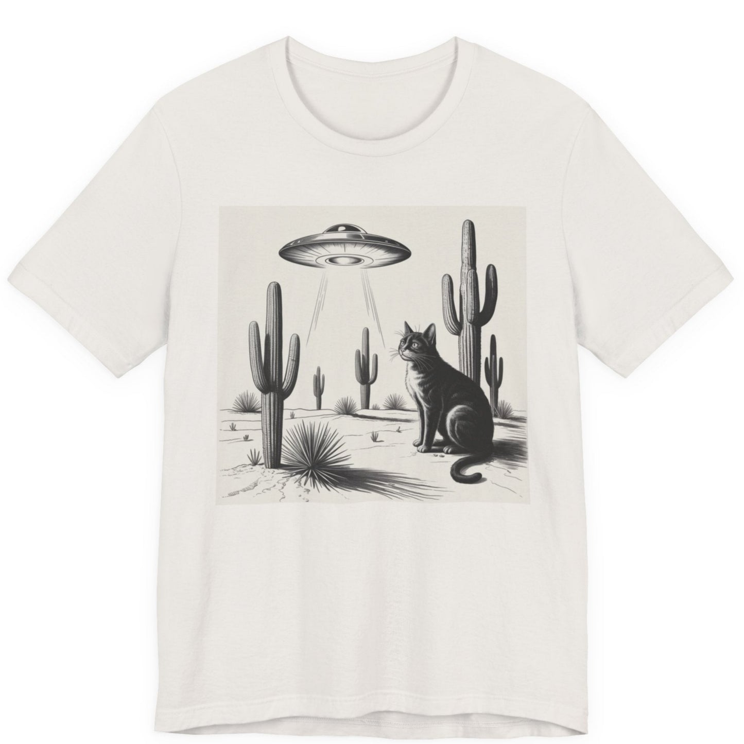 White t-shirt with a graphic of a cat and cacti under a UFO in a desert landscape.