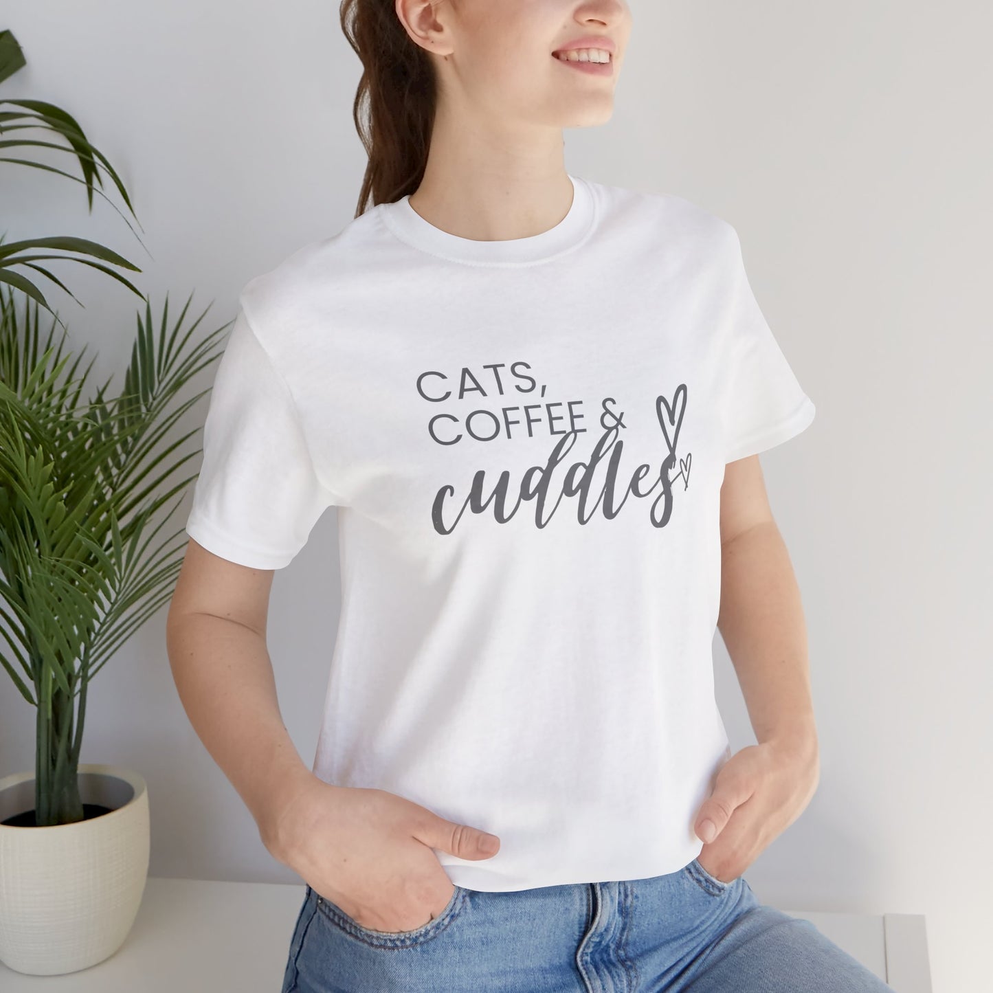 Cats, Coffee, Cuddles Tee Embrace the blissful trifecta of cats, coffee, and cuddles with this delightfully cozy tee. Whether you're curled up on the couch or out and about, this tee lets the world know your priorities - and they're purrfect. Product feat
