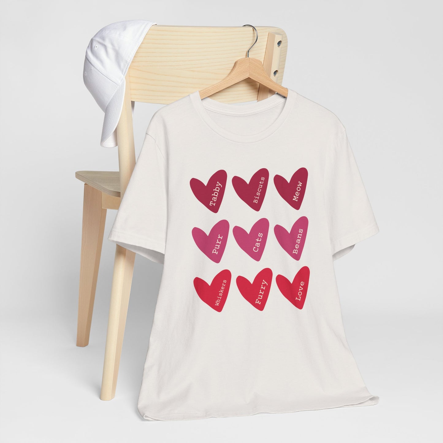 Cat Hearts Valentine’s Day Tshirt This T-Shirt features a cute design of Valentine's Day hearts with various cat types, giving off a playful and festive vibe. It is perfect for cat lovers celebrating Valentine's Day or looking to add a fun touch to their