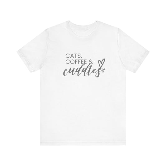 Cats, Coffee, Cuddles Tee Embrace the blissful trifecta of cats, coffee, and cuddles with this delightfully cozy tee. Whether you're curled up on the couch or out and about, this tee lets the world know your priorities - and they're purrfect. Product feat