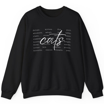 sweatshirt with a centered cursive text of"cats". In the backround are smaller words describing cats