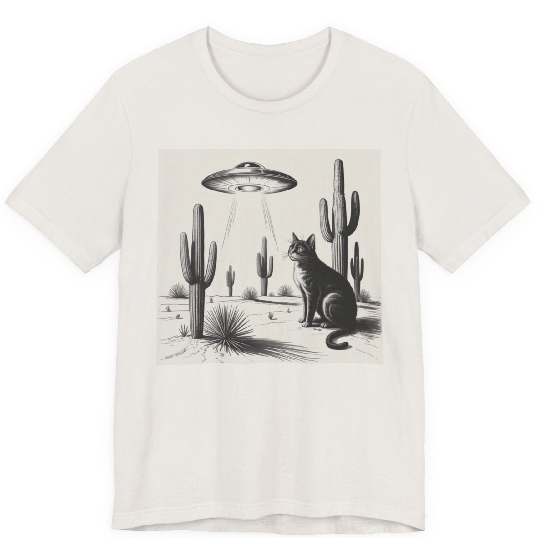 White t-shirt with a graphic of a cat and cacti under a UFO in a desert landscape.
